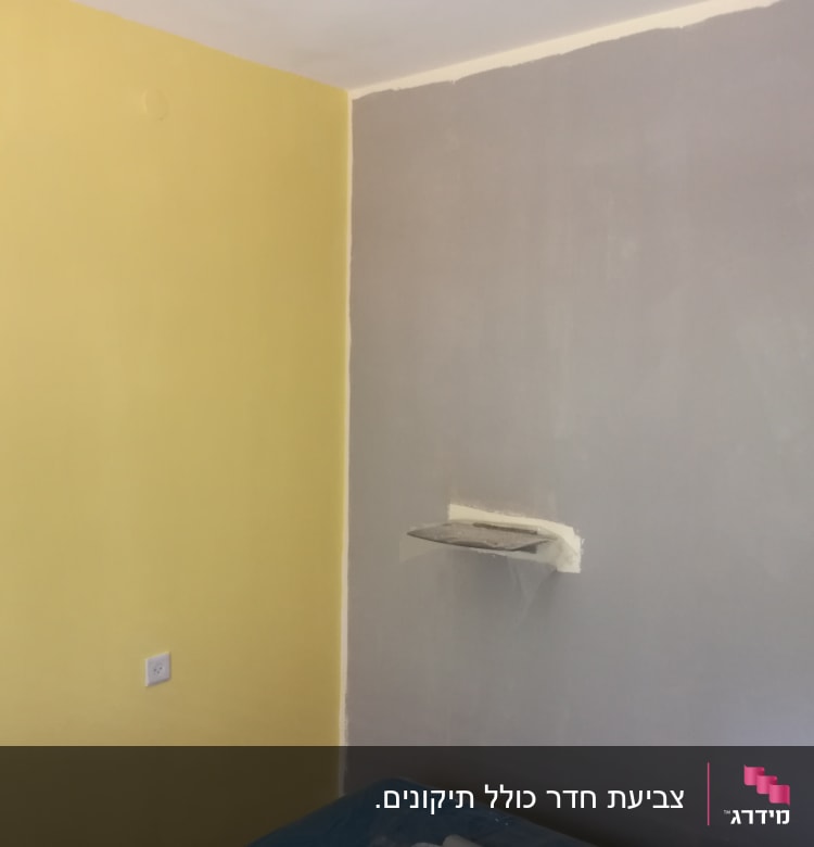 קיר צבוע בצהוב ואפור עם מדף קטן